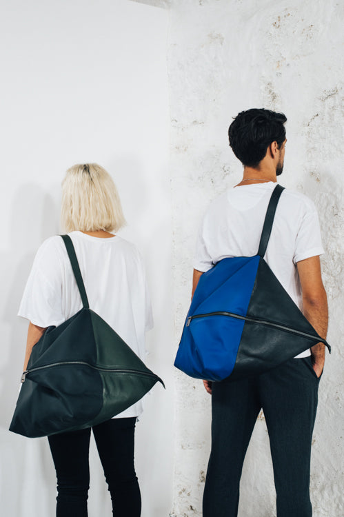 women and man with large backpack in black leather and waterproof material